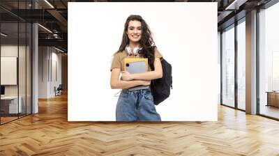 Portrait of a smiling young teenage girl wearing backpack and holding pc tablet isolated over white background Wall mural